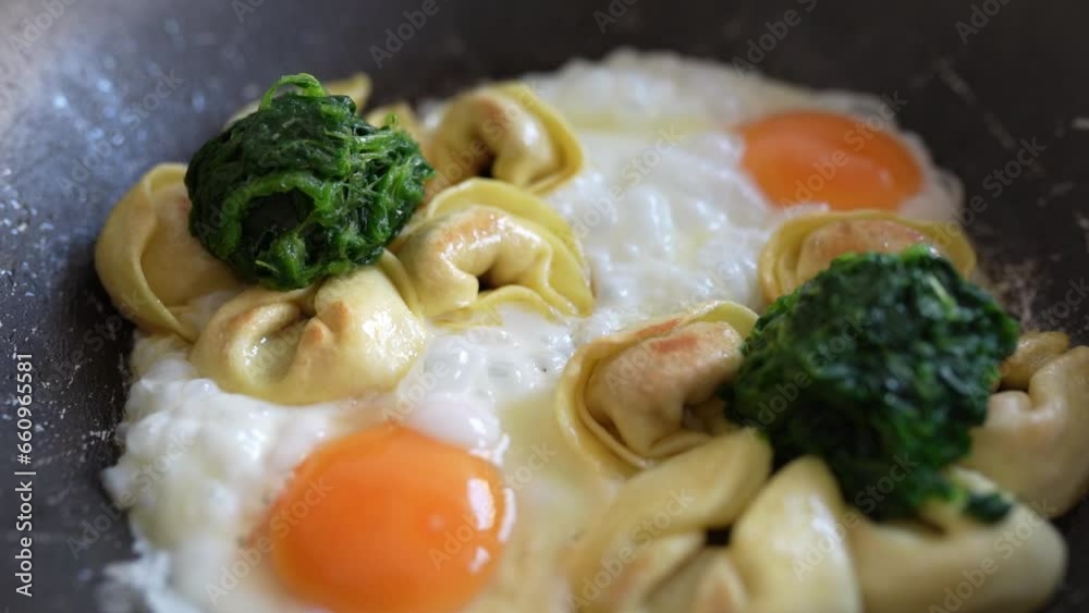 fried eggs with tortellini and spinach in frying pan fried eggs with tortellini and spinach in frying pan