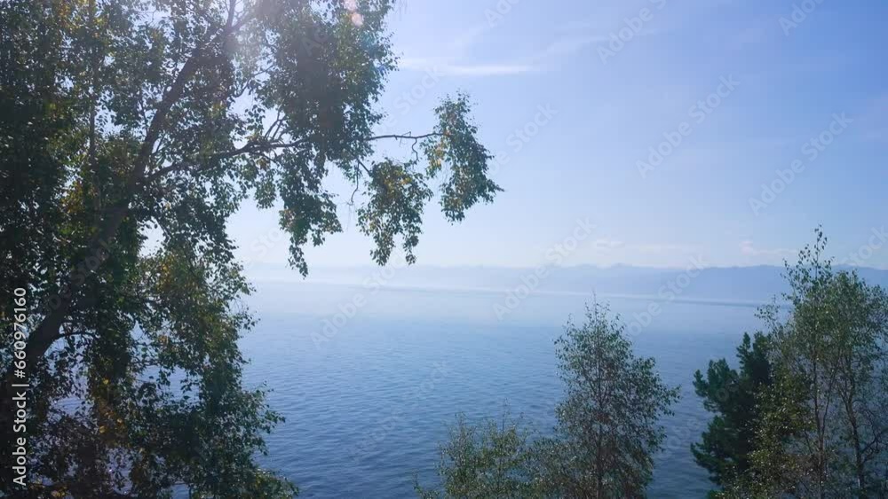Lake Baikal from the window of a passing train. Views of Lake Baikal of different scales in sunny summer weather. Siberia