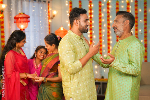 Happy Son with daughter in law and kids came for diwali festival celebration to grand parents home - concept of family gathering, relationship bonding and traditional Indian culture.