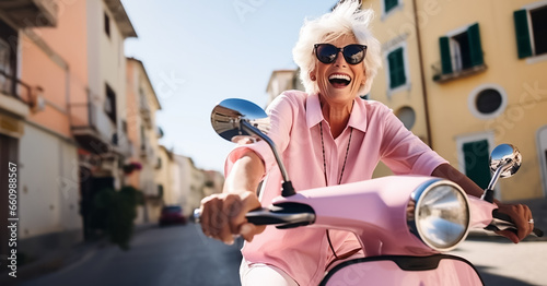 Old woman or senior citizen riding motor scooter through southern Italy in summer - retirement theme or staying young