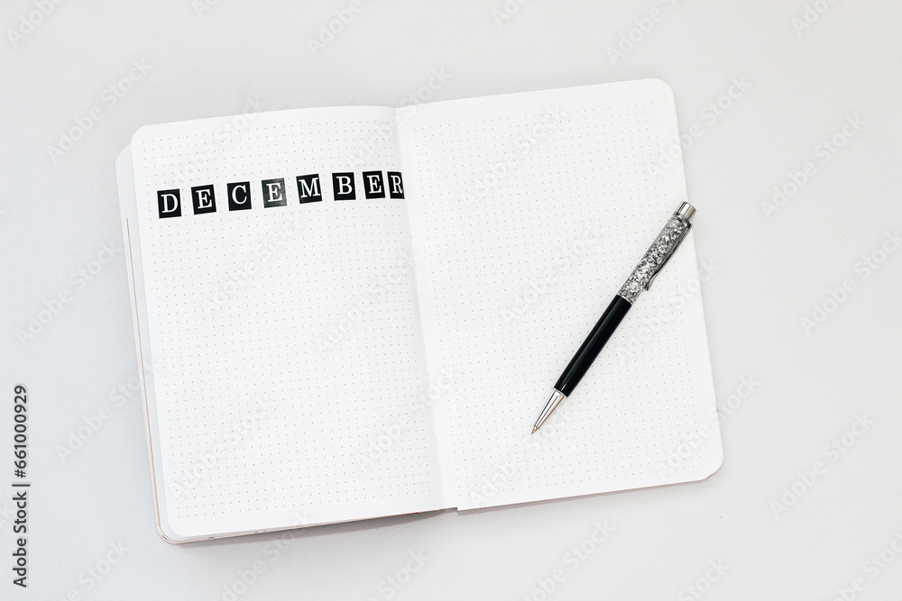 Filling in the diary, writing December in a notebook in a dot Filling in the diary, writing December in a notebook in a dot