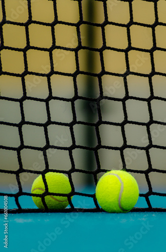 selective focus, two paddle tennis ball near the net in a blue paddle tennis court © Vic