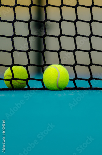 selective focus of two paddle tennis ball near the net in a blue paddle tennis court. racket sports concept
