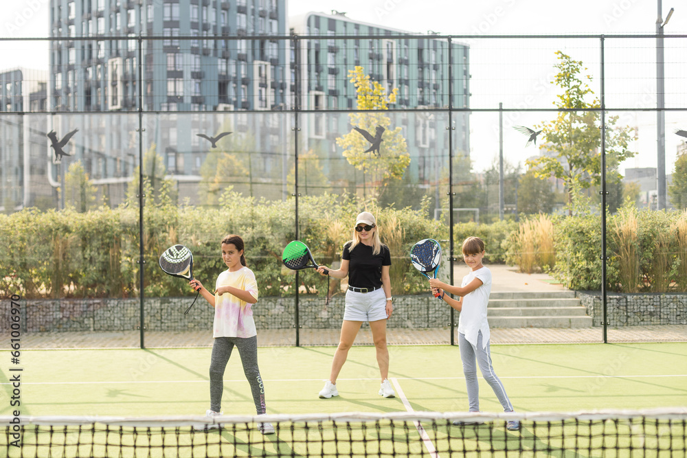 mother and daughters playing padel outdoor
