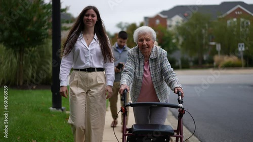 Wallpaper Mural Grandmother using a walker and granddaughter smiling and walking together outside. Torontodigital.ca