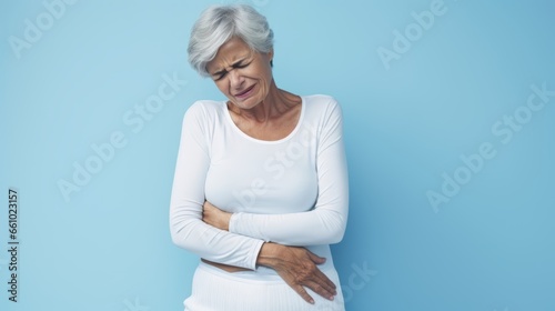 An old woman with stomach pain infront of a clean one colored background.generative ai 