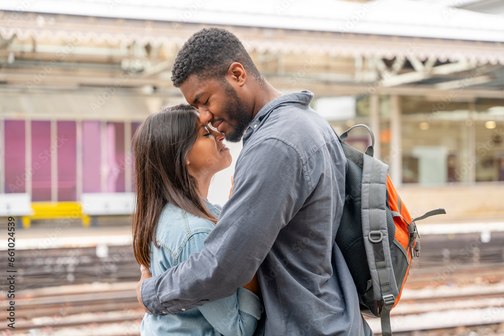 Happy couple embracing on railway station platform. Meeting, saying goodbye the spouse, friends. Travel lifestyle concept