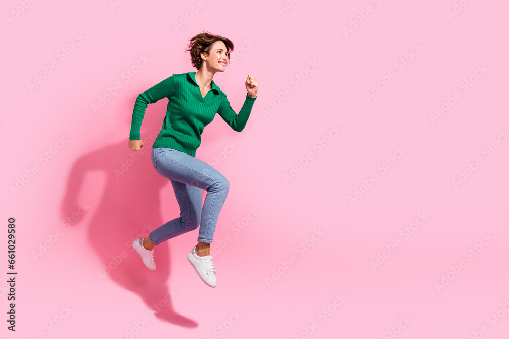 Full body length view of running sporty fit young girl looking empty space motivation to work more isolated on pink color background