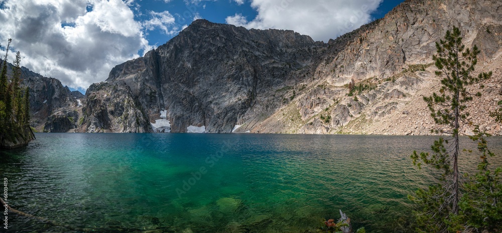 Obraz premium a lake that has some clear water with mountains in the background