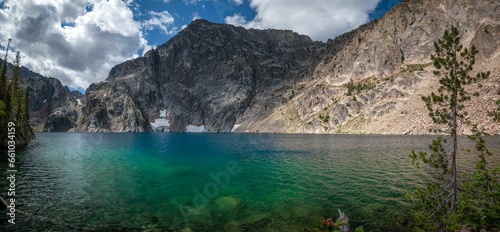 a lake that has some clear water with mountains in the background