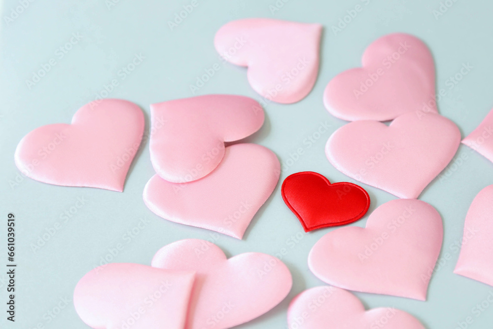 The red decorative heart is in the middle of pink hearts on a blue background.