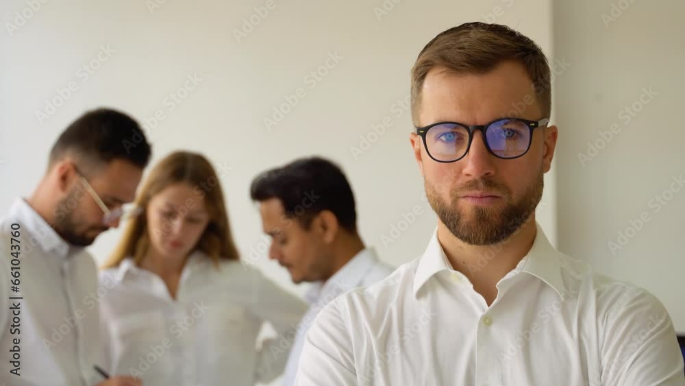 Confident mature businessman leader looking at camera standing in office at team meeting Confident mature businessman leader looking at camera standing in office at team meeting