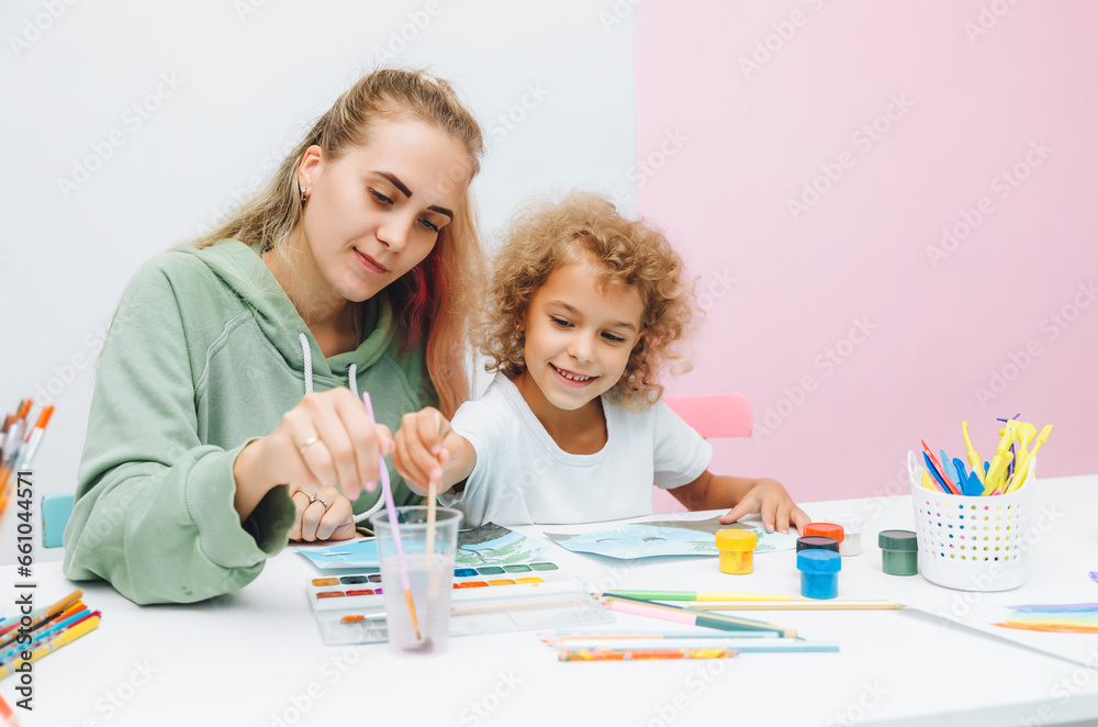mother and child draw. daughter is engaged in creativity. mother and daughter paint. mother and child draw. daughter is engaged in creativity. mother and daughter paint.