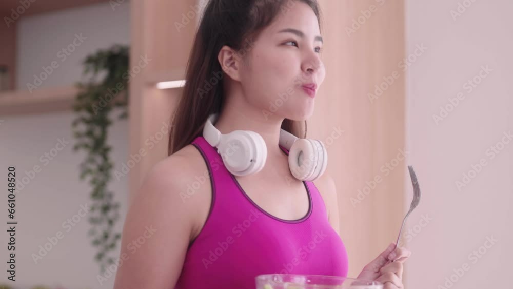 sporty young Asian woman in sportswear hold salad bowl eating healthy fresh vegetable salad after workout keeping weight loss diet and Healthy food concept. sporty young Asian woman in sportswear hold salad bowl eating healthy fresh vegetable salad after workout keeping weight loss diet and Healthy food concept.