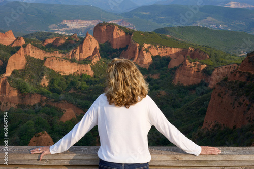 Unrecognizable mature woman looking at the rugged amazing landscape of the ancient Roman gold mine of Las Médulas; trip, getaway, vacation concept. UNESCO World Heritage, León, Spain. photo