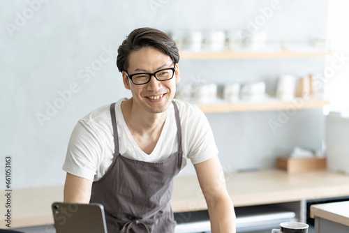 笑顔で接客するカフェ店員男性