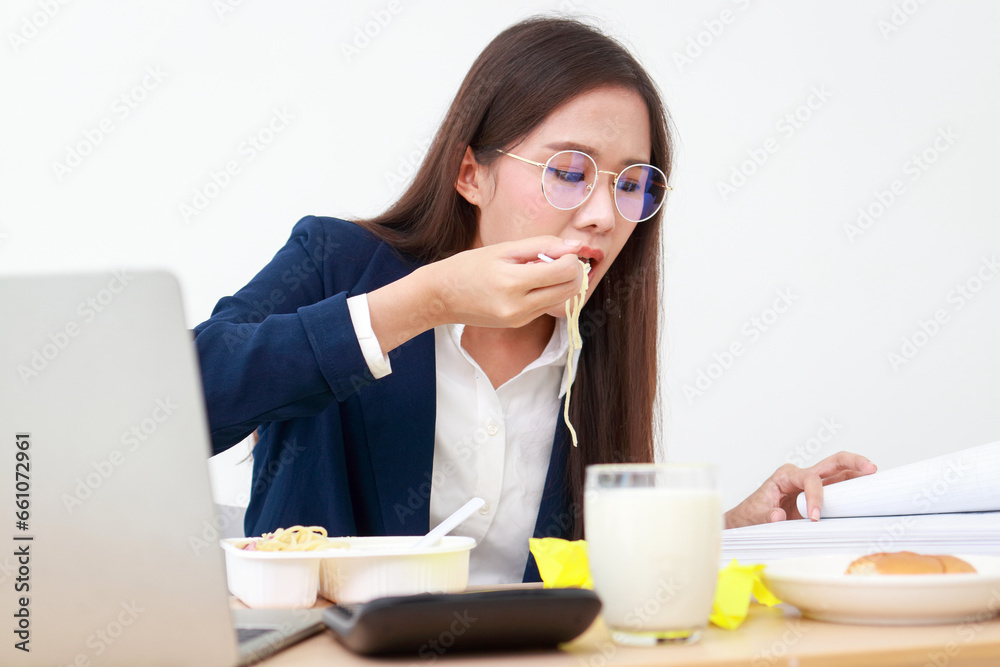 Beautiful Asian manager working in the office She works and eats at the same time. Eating healthy food. Working age. Business concept Beautiful Asian manager working in the office She works and eats at the same time. Eating healthy food. Working age. Business concept