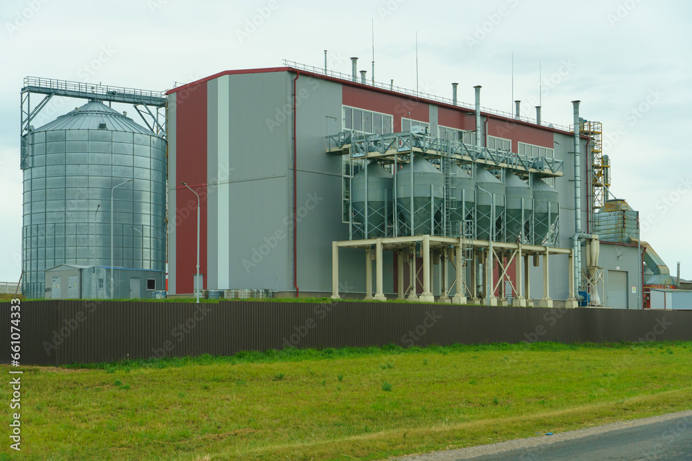 silver silos on agro manufacturing plant for processing drying cleaning and storage of agricultural products, flour, cereals and grain. Large iron barrels of grain. Granary elevator silver silos on agro manufacturing plant for processing drying cleaning and storage of agricultural products, flour, cereals and grain. Large iron barrels of grain. Granary elevator