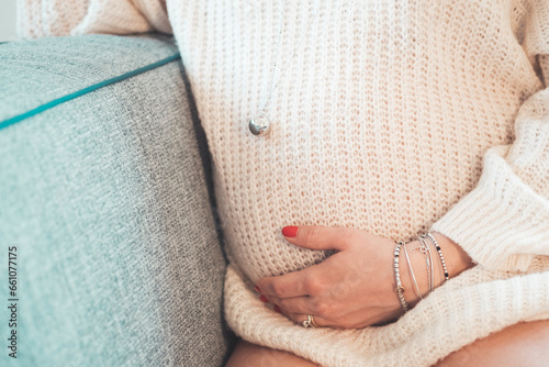 donna in gravidanza con maglione e chiamangeli photo