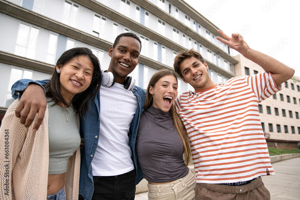 Happy multiracial group of friends having fun looking at camera.Diverse cheerful young people laughing standing outside. Happy multiracial group of friends having fun looking at camera.Diverse cheerful young people laughing standing outside.