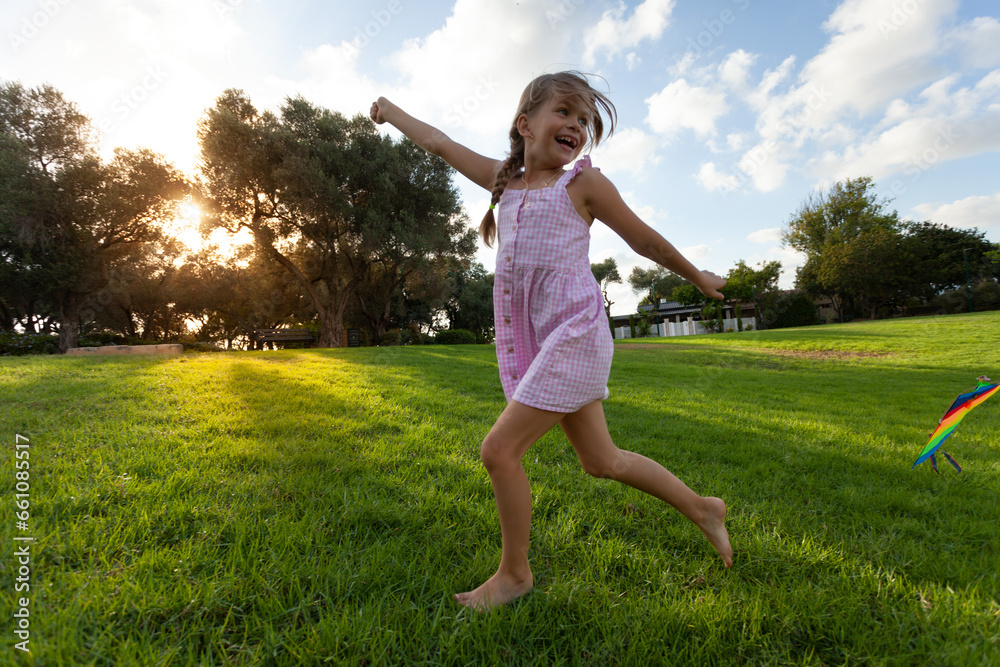 Happy child running with a rainbow kite Happy child running with a rainbow kite