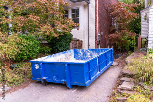Photography A small roll-off construction dumpster blue outside a residential renovation project in an older neighourhood