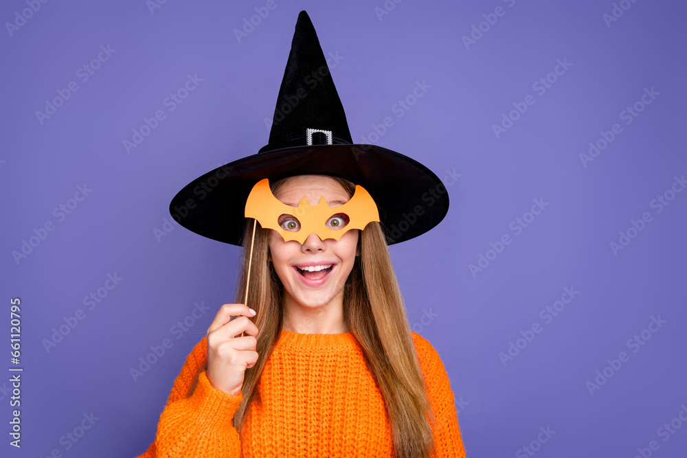 Portrait of using bat mask masquerade halloween party young girl having fun spooky atmosphere death day isolated on violet color background