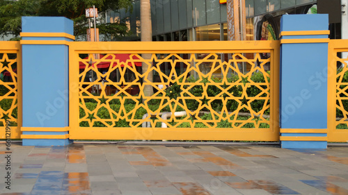 Backdrop of yellow guardrail with ornamental Turkish ottoman star Islamic pattern.