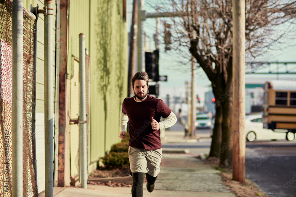 Young man jogging beside a road in the city