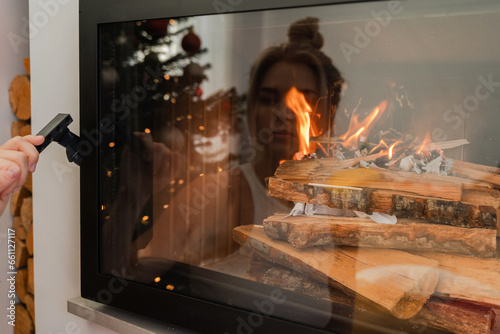 Burning fireplace and reflection of a woman's face in the glass