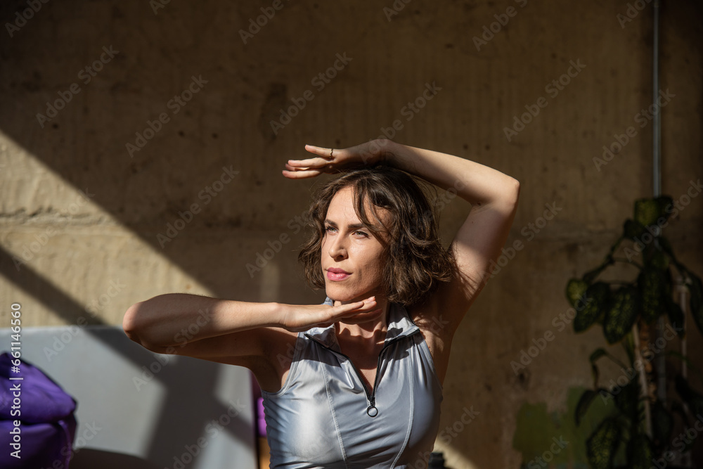 Fototapeta premium A girl dances a contemporary dance in a sunlit studio
