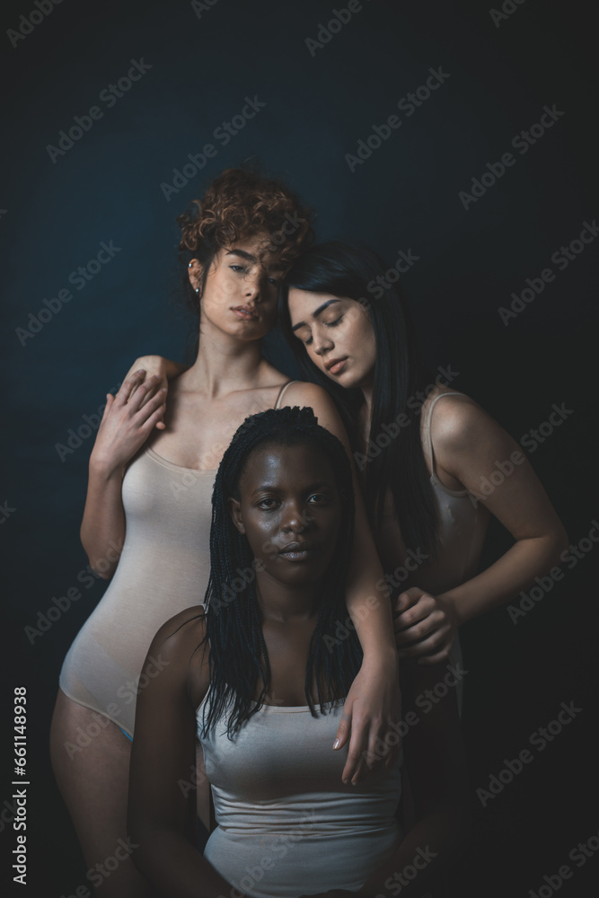 Three girls from different ethnicities posing in studio for a Three girls from different ethnicities posing in studio for a