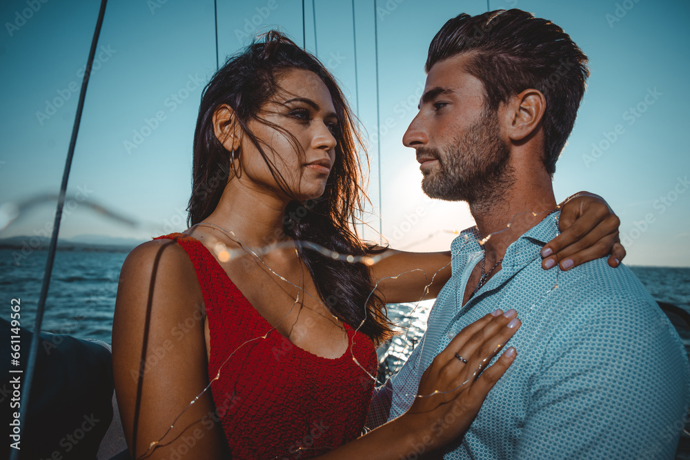 happy couple taking a romantic cruise on the sail boat - obrazy, fototapety, plakaty 