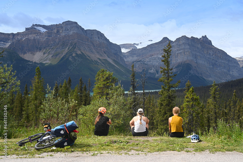 Cyclists rest in the mountains. Tourists in Banff National Park, Alberta, Canada. - obrazy, fototapety, plakaty 