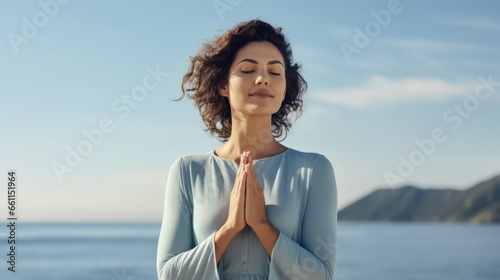 Caucasian woman practicing yoga with hands together under a vibrant sky