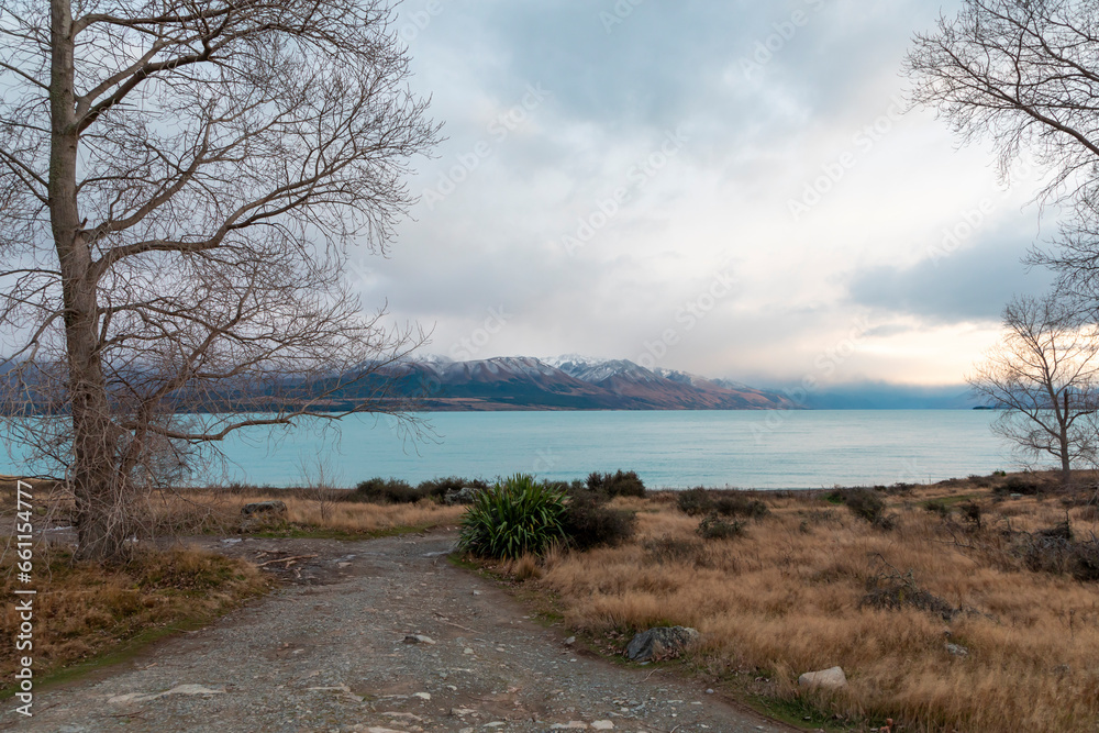 Photograph of Lake Pukaki early in the morning on a cloudy day with snow-capped mountains in the background on the South Island of New Zealand
