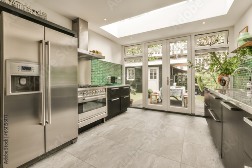 Kitchen with modern appliances and cabinet by window photo