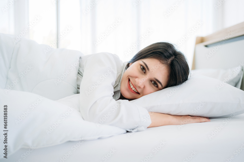 Young Woman Waking Up with Happiness in Cozy Bedroom at Home. Beautiful Girl Smiling and Relaxing in Bed after Waking Up. Young Woman Waking Up with Happiness in Cozy Bedroom at Home. Beautiful Girl Smiling and Relaxing in Bed after Waking Up.