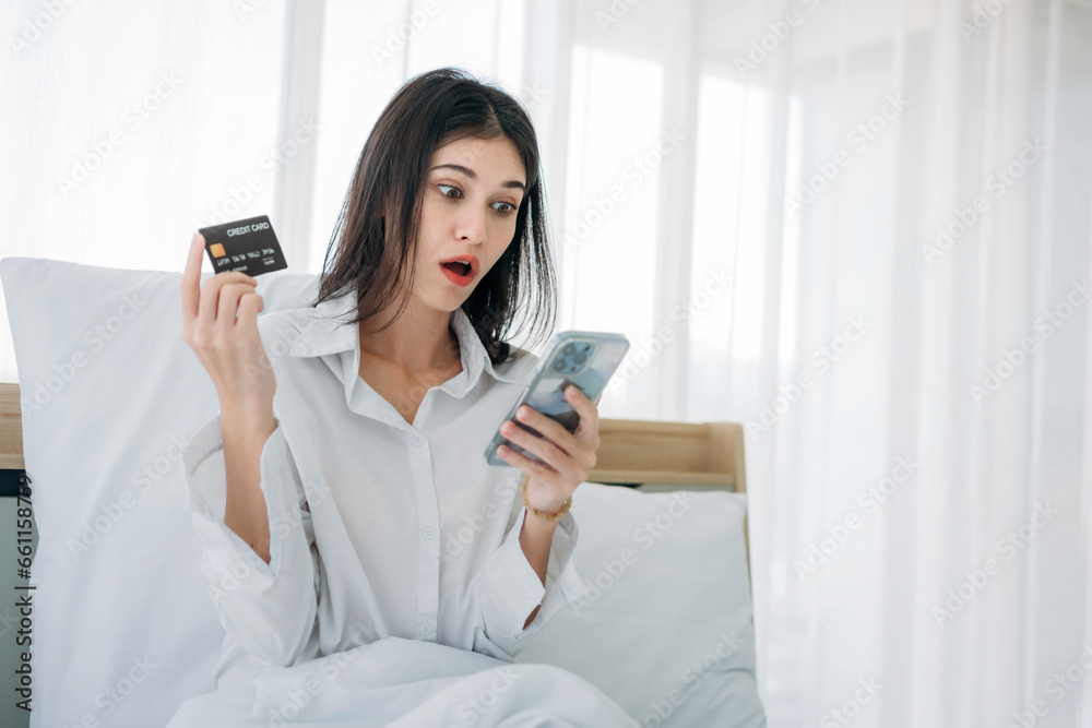 Young Woman Shopping online in Bedroom at Home. Beautiful Girl Smiling and Relaxing in Bed after Waking Up. Young Woman Shopping online in Bedroom at Home. Beautiful Girl Smiling and Relaxing in Bed after Waking Up.