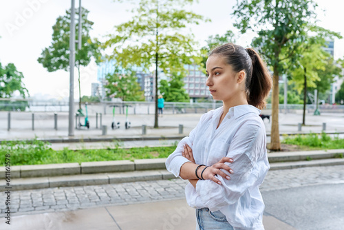 Serious confident teenage girl looking forward, outdoor on city street © Valerii Honcharuk