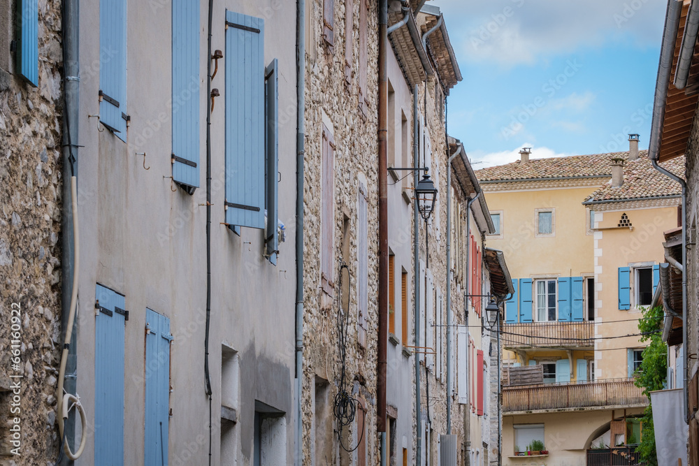 Narrow street and old house stone facades with shutters in the medieval village of Chatillon en Diois, in the south of France (Drome)