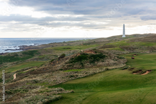 Photograph of Cape Wickham Lighthouse on a hill in a large green field overlooking Bass Strait on King Island in Tasmania in Australia photo