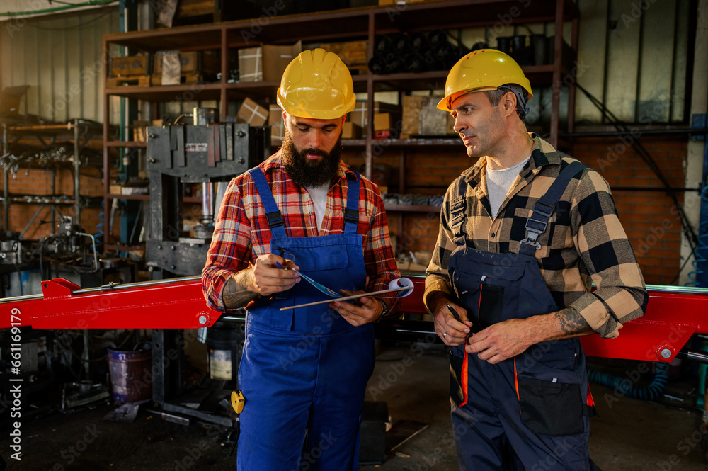 Workers standing in a mechanics shop and brainstorming new ideas. Workers standing in a mechanics shop and brainstorming new ideas.