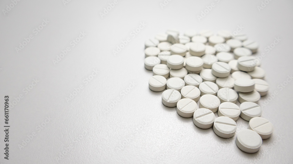 White pills on white background with negative space to the left. White pills on white background with negative space to the left.