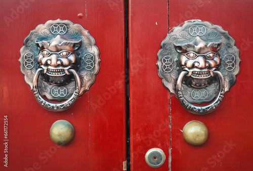 Beijing, China - April 3, 2013: Red door with dragon head door-knocker in hutong area, Beijing photo