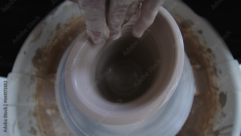 Embark on a journey of awe as the artistry of a fiercely independent female ceramicist unfolds before your eyes. With eloquence and precision, she sculpts a graceful clay vessel on the potter's wheel Embark on a journey of awe as the artistry of a fiercely independent female ceramicist unfolds before your eyes. With eloquence and precision, she sculpts a graceful clay vessel on the potter's wheel