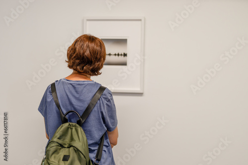 girl looking at a small painting in a museum