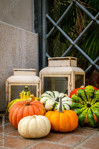Series of colorful market pumpkins in front of the front door with lanterns