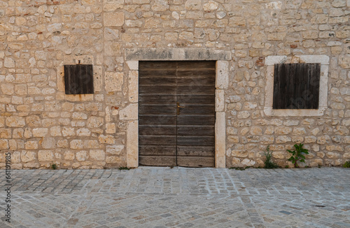 old wooden door in the wall made from limestone © michal812