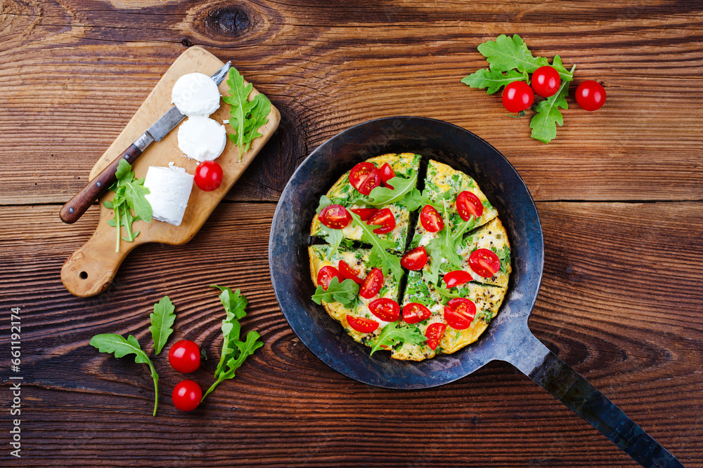 Traditional German vegetarian rucola omelet with cherry tomatoes and cream goat cheese served as